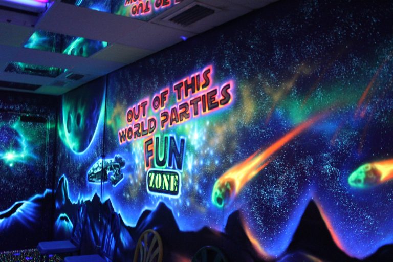 Cosmic themed party room at Fun Zone Skate Center, featuring vibrant neon lights and stars for an out-of-this-world experience.