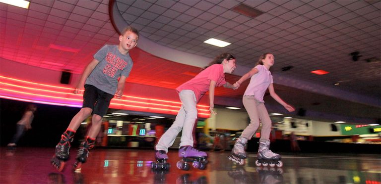 Smiling children roller skating at Fun Zone, making memories on the rink.