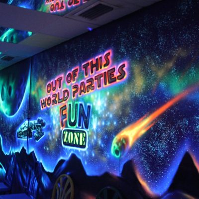 Cosmic themed party room at Fun Zone Skate Center, featuring vibrant neon lights and stars for an out-of-this-world experience.